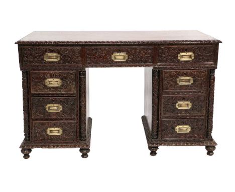 An Anglo-Indian Carved Padouk Wood Double Pedestal Desk, late 19th century, the rectangular top with a carved border above an