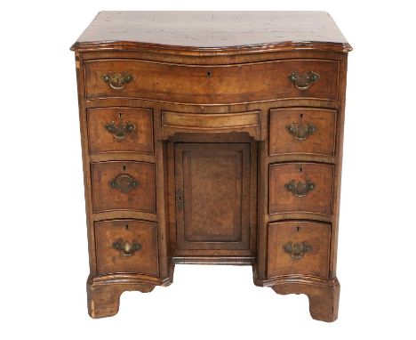 An Early 20th Century Walnut Crossbanded and Featherbanded Kneehole Dressing Table, the top above a serpentine frieze drawer 