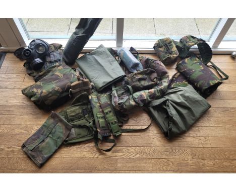 A collection of modern military camping and hiking equipment, including an 1984 respirator, sleeping bags, holsters and sheat
