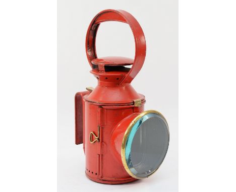 A red London Transport three aspect hand lamp (Cast stamped L.T) complete with burner