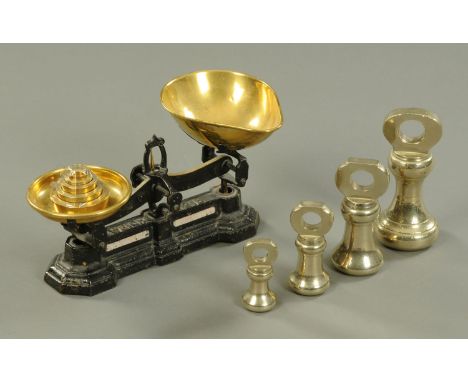 A set of four brass bell weights, 1 pound to 7 pounds, and balance scales and weights.  