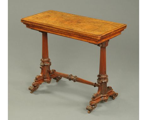 A Victorian walnut turnover top games stretcher table, with green baize lined playing surface, turned and fluted end supports
