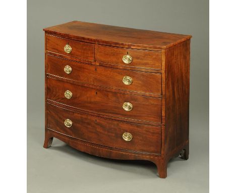 A Georgian mahogany bowfronted chest of drawers, two short and three long drawers with brass drop handles with oval backplate