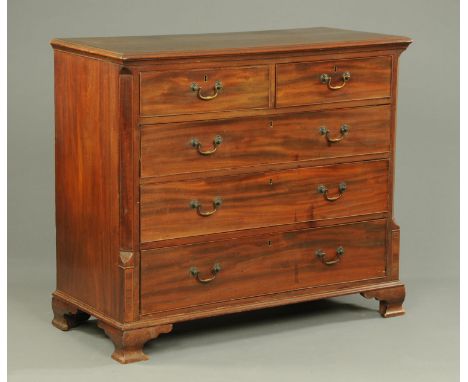 A George III mahogany chest of drawers, with moulded edge, canted angles, two short and three long graduated drawers with bra