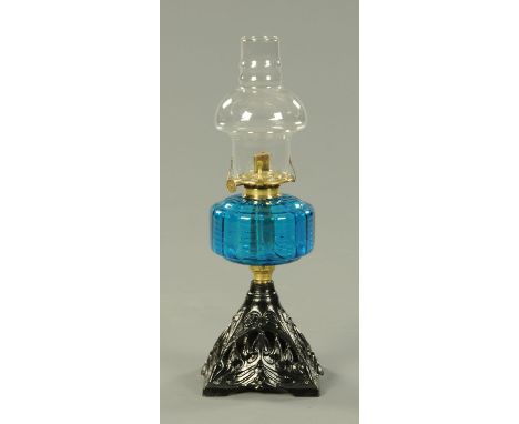 A Victorian oil lamp, with black painted metal base and blue glass reservoir.  Height 46 cm. 