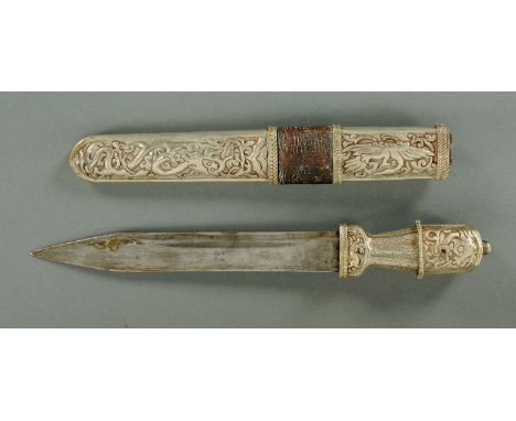 An Eastern dagger, with silver coloured metal handle and scabbard.  Length 34 cm (see illustration).