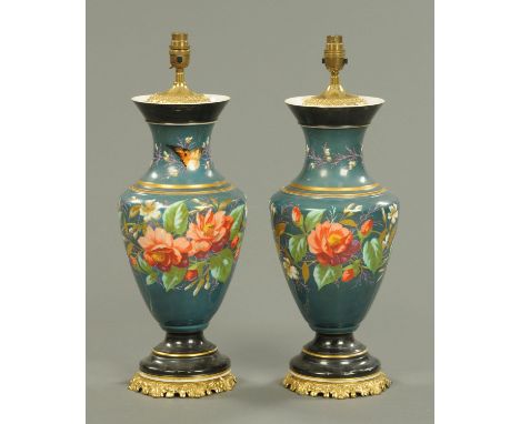 A pair of porcelain lamp bases, each raised on a metal plinth, foliate patterned.  Height excluding light fitting 44 cm (see 