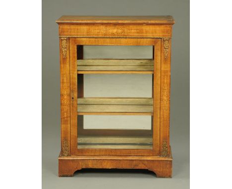 A Victorian walnut pier cabinet, with single glazed door enclosing shelves, flanked by flat pilasters and raised on bracket f