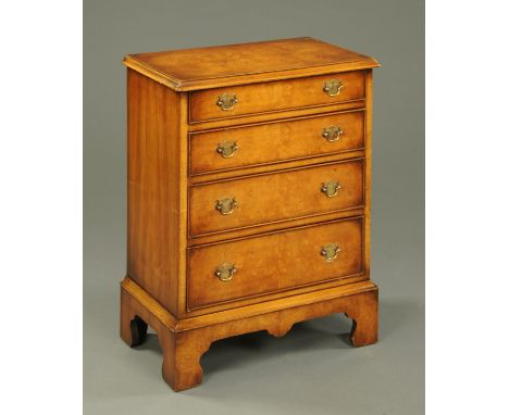 A walnut chest of drawers, reproduction, four long graduated drawers with brass drop handles and raised on bracket feet.  Wid