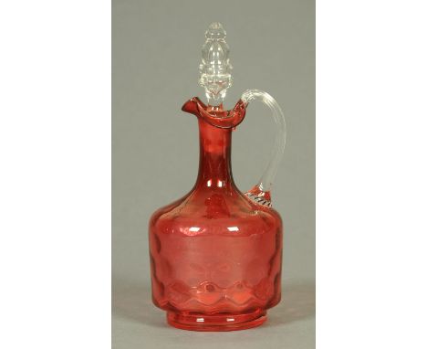 A Victorian cranberry glass dimpled decanter with stopper.
