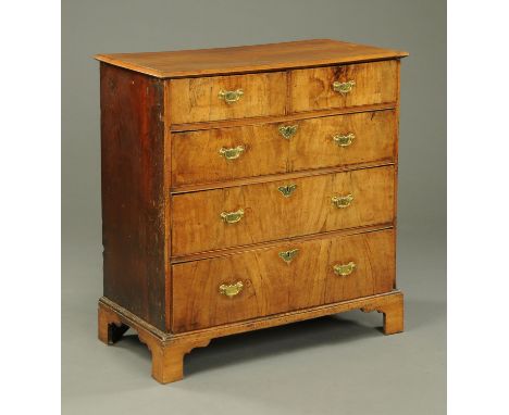 An antique walnut chest of drawers, with moulded edge above two short and three long graduated drawers with brass drop handle