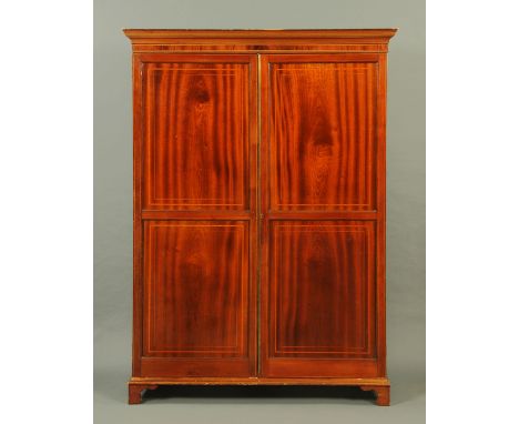 A Georgian mahogany wardrobe, with moulded cornice above a pair of panelled doors being boxwood strung and satinwood banded a