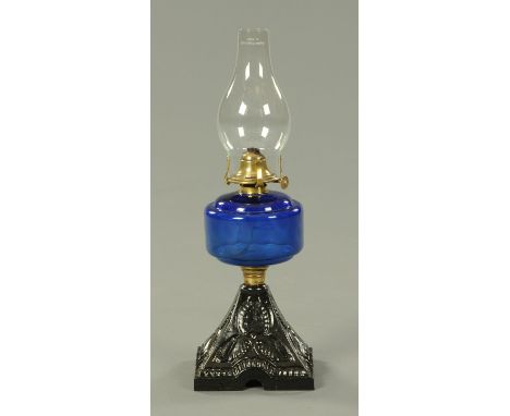 A Victorian oil lamp, with painted metal base and Bristol blue glass reservoir.  Height 42 cm. 