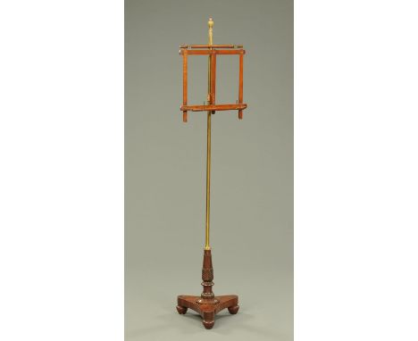 A Regency mahogany and brass adjustable music stand, raised on a triform base with bun feet (see illustration).     CONDITION