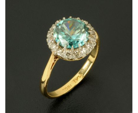 An 18 ct gold aquamarine and diamond ring, circular, stamped "18 ct", size N/O (see illustration).   CONDITION REPORT:  The a