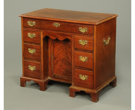 A George III mahogany kneehole desk, with single frieze drawer above a centre recessed cupboard and three further drawers to 