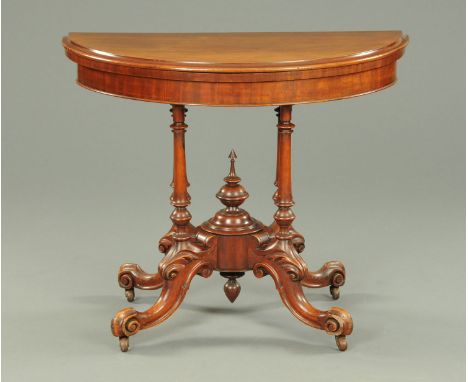 A Victorian mahogany and walnut demi-lune turnover top card table, with baize lined playing surface and raised on four turned