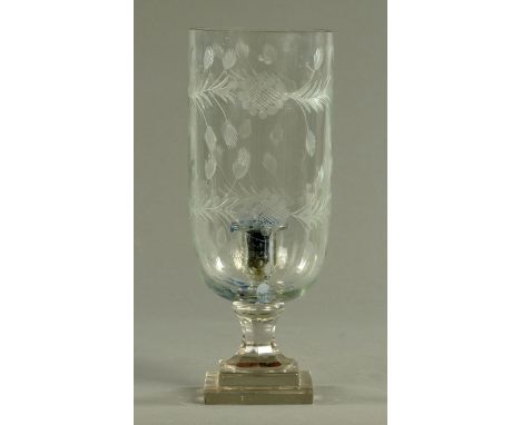 An engraved glass storm lamp, with integral candle holder.  Height 38 cm. 