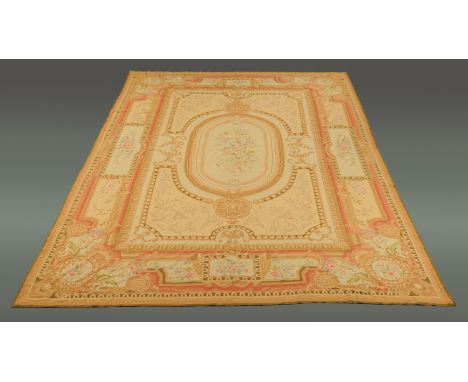 An Aubusson style tapestry rug, principal colours beige, pink and green.  Approximately 430 cm x 340 cm (see illustration).  