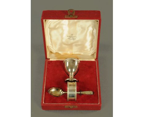 A silver christening set, egg cup, serviette ring and spoon, Sheffield 1956, cased.  
