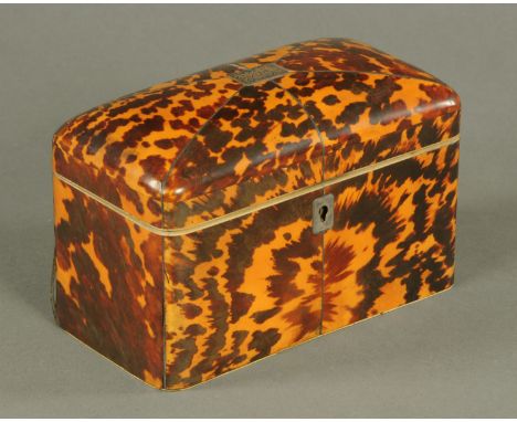 An early 19th century tortoiseshell tea caddy, with two lidded interior compartments and silver coloured metal lock escutcheo