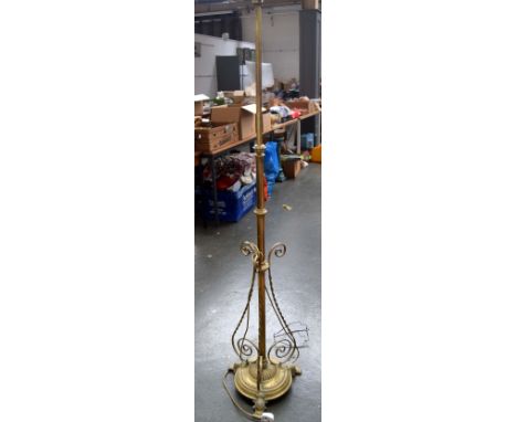 A Victorian brass telescopic floor lamp, on paw feet and the column with three scroll buttress supports, 173cmH