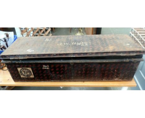 A black painted metal travel trunk with side handles, painted on the top 'J. W Rigby R.N' with attached travel labels 108 x 3
