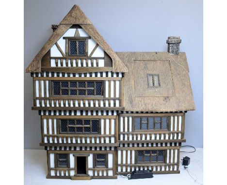 A four-storey Tudor-style doll's house by Robert Stubbs of Norfolk, 1/12th scale, with simulated thatched roof, the seven roo