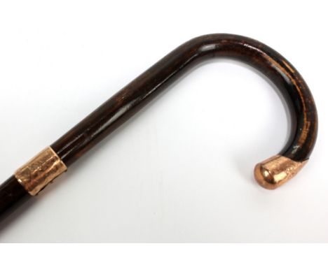 A walking stick with 9ct rose gold collar and unmarked rose metal mount to handle, length 92.5cm. CONDITION REPORT: Dents and