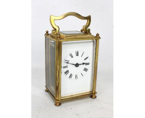 An early 20th century brass carriage clock, the white enamel rectangular dial set with Roman numerals, the door no.17, in lea