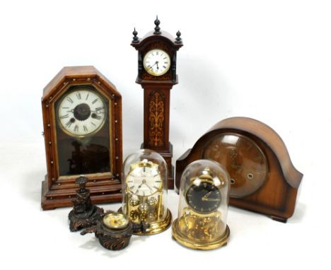 A group of mantel clocks including miniature longcase clock and two modern clocks on circular bases under glass domes (some i