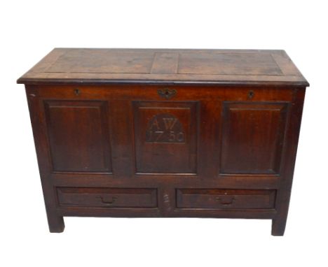 An 18th century blanket chest with three fielded panels, the central panel carved 'AW 1750' above two drawers to stile suppor