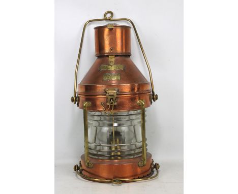 A large copper and brass mounted 'Meteorite' ship's lamp, number 67906, height 55cm excluding loop handle.
