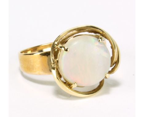 A yellow metal ring set with round cut opal in raised stylised arrangement, size O, approx 3.3g, boxed. 