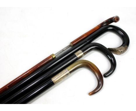 Three ebonised white metal mounted walking sticks, two with horn handles, and a malacca brass mounted sword stick, length 83c