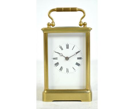 A brass cased carriage clock, the circular dial set with Roman numerals, height excluding handle 12.3cm. CONDITION REPORT: Ru