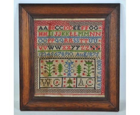 A Victorian woolwork alphabetical and numerical sampler with floral motifs and Greek key border, dated August 1875, 31 x 28.5
