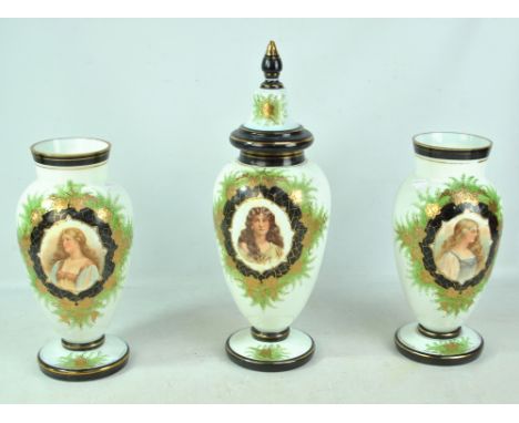 A garniture of late Victorian opaque glass and portrait decorated gilt heightened urns, the central example with cover, heigh