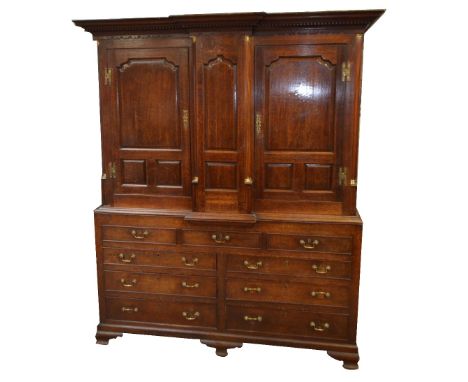 A George III oak housekeeper's cupboard, converted to a wardrobe, the upper breakfront section with dentil moulded cornice ab