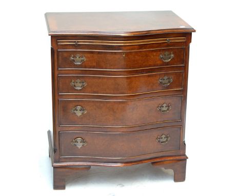 A reproduction walnut and crossbanded serpentine fronted bachelor's chest, the brushing slide above four long drawers flanked