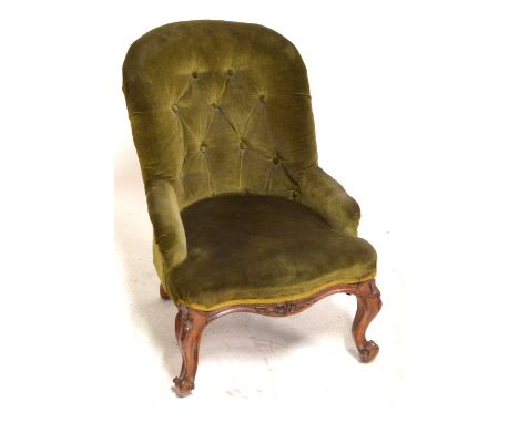 A low button upholstered side chair on carved walnut cabriole front legs.