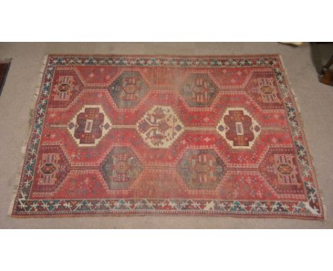 A Kelim rug with central red ground panel set with conjoined medallions within a simple stylised border, 235 x 163cm.