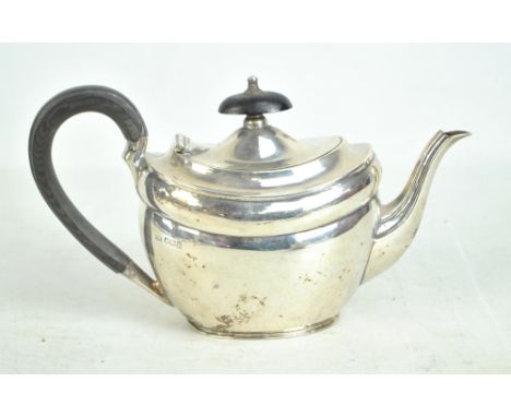 AITKIN BROTHERS; a small George V hallmarked silver teapot of oval form, with ebony finial and C-scroll handle, Sheffield 191