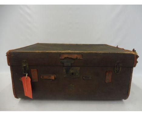 A tan leather and brown canvas covered travel trunk. 