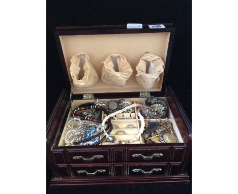 A jewellery box and contents including a heavy silver bangle and various gold coloured and costume jewellery items.