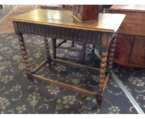 An oak side table with single drawer, resting on bobbin turned cross stretcher supports.