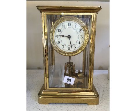 A good quality brass and glass cased Anniversary clock with white enamel dial, decorated with swags of flowers.