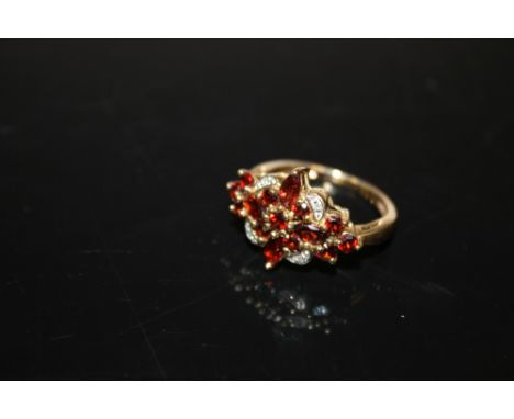 A 9 CARAT GOLD GARNET AND DIAMOND CLUSTER RING