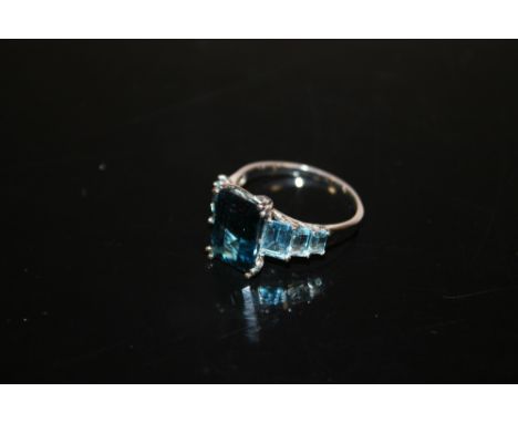 A HALLMARKED 9CT GOLD LADIES DRESS RING SET WITH BLUE EMERALD CUT STONES 