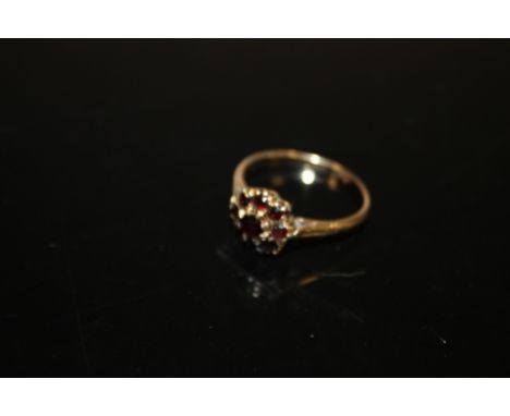 A 9 CARAT GOLD FLORAL STYLE GARNET RING 